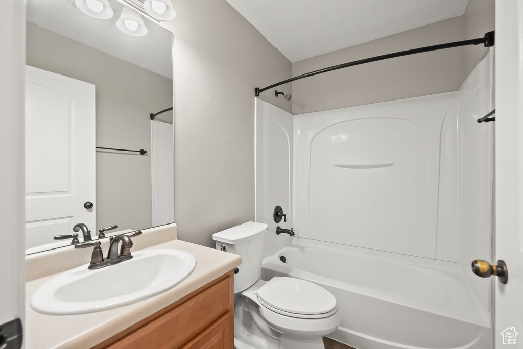 Full bathroom featuring bathtub / shower combination, vanity, and toilet