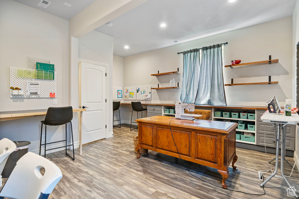 Office featuring built in desk and wood-type flooring