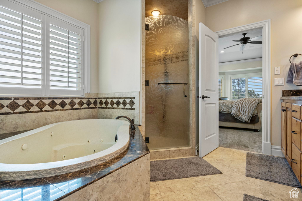 Bathroom featuring ceiling fan, crown molding, tile flooring, walk in shower, and vanity