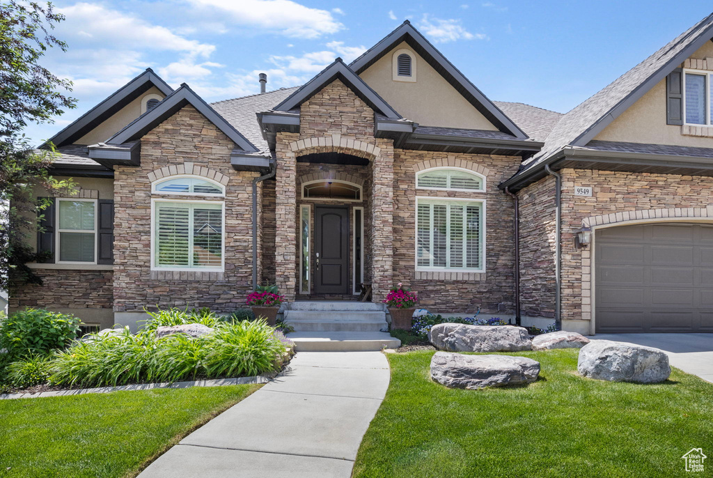 View of front of home featuring a front lawn and a garage