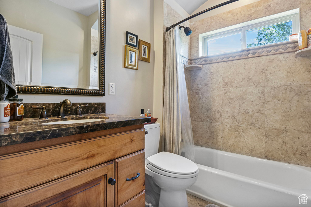 Full bathroom featuring shower / bathtub combination with curtain, vanity, and toilet