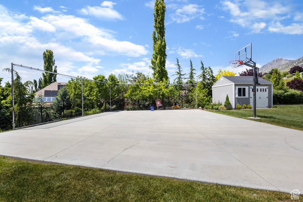 View of basketball court featuring a lawn and a mountain view