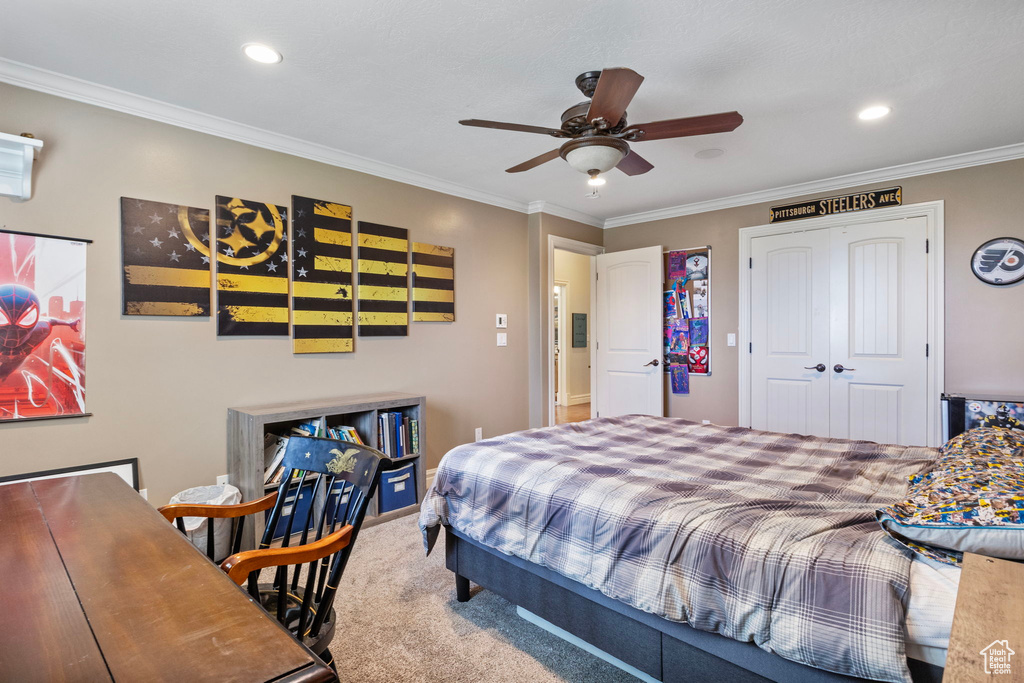 Carpeted bedroom with crown molding, a closet, and ceiling fan