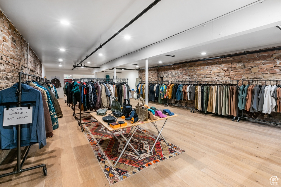 Walk in closet with light hardwood / wood-style floors