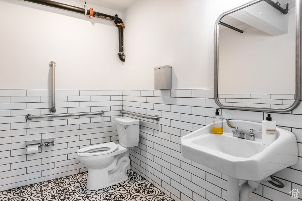 Bathroom with tile walls, tile floors, tasteful backsplash, and toilet