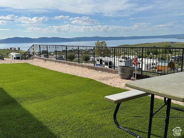 Exterior space with a lawn and a water and mountain view