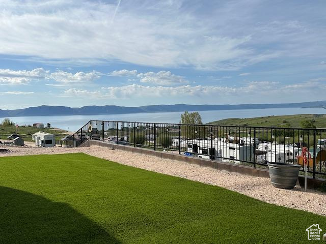 Surrounding community with a yard and a water and mountain view