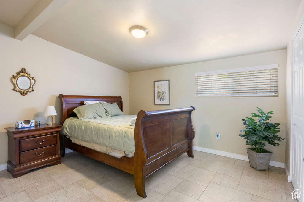 Tiled bedroom featuring beam ceiling