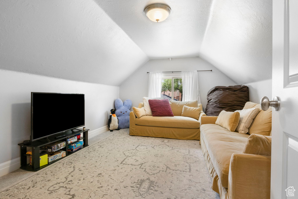 Living room featuring carpet and vaulted ceiling