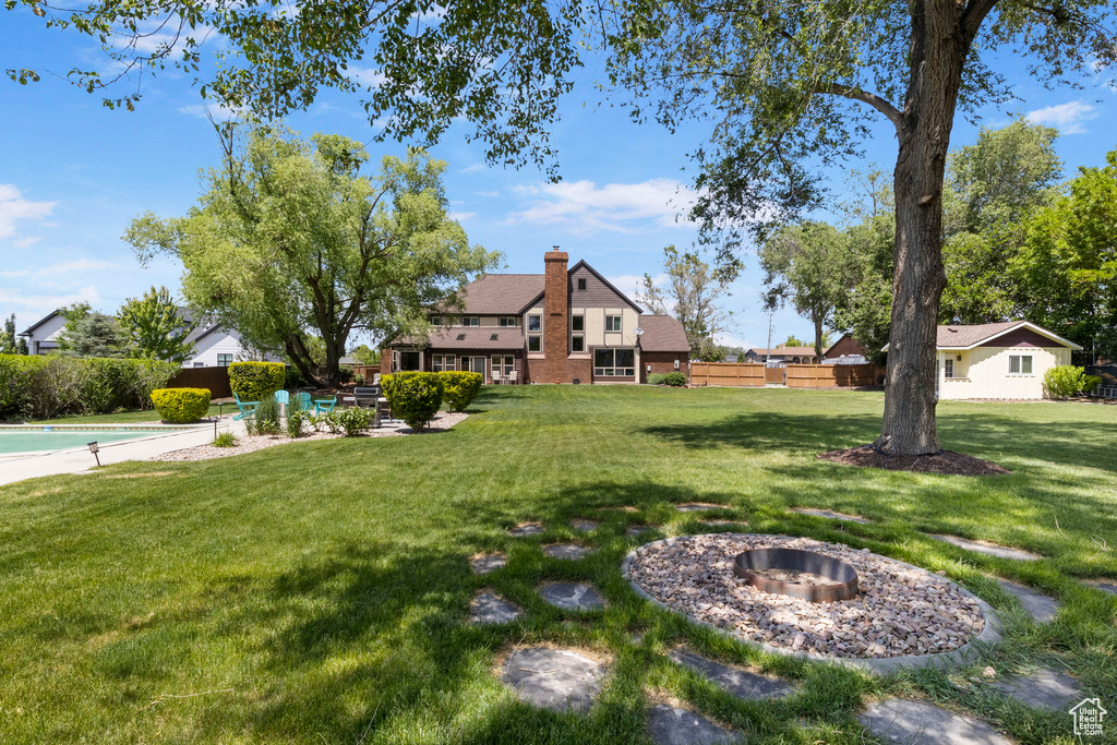 View of yard with a fire pit and a fenced in pool