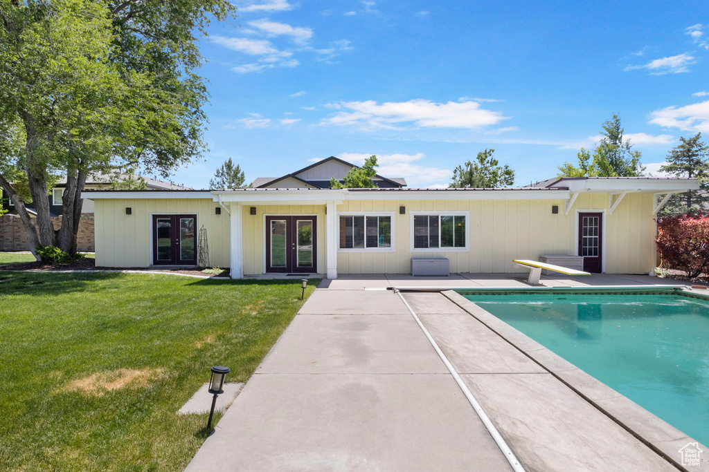 Exterior space featuring a yard, french doors, and a patio