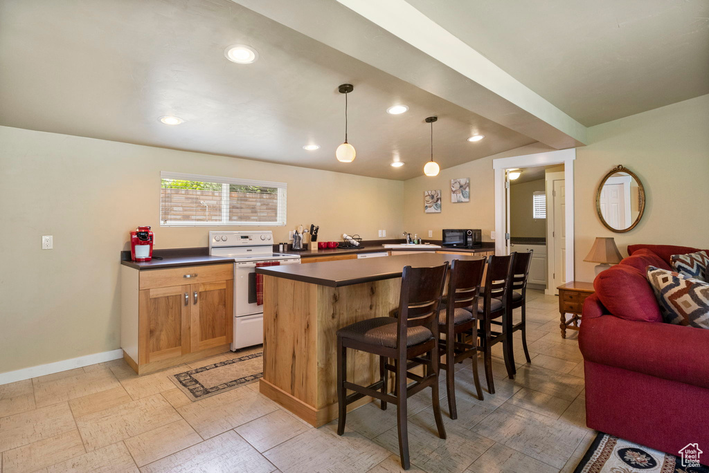 Kitchen with a center island, lofted ceiling, electric stove, pendant lighting, and light tile flooring