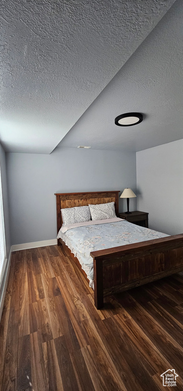 Unfurnished bedroom featuring hardwood / wood-style flooring and a textured ceiling