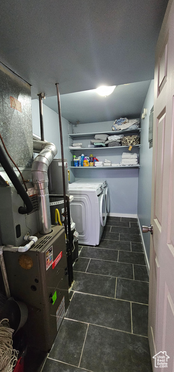 Laundry area featuring washer and clothes dryer and dark tile floors