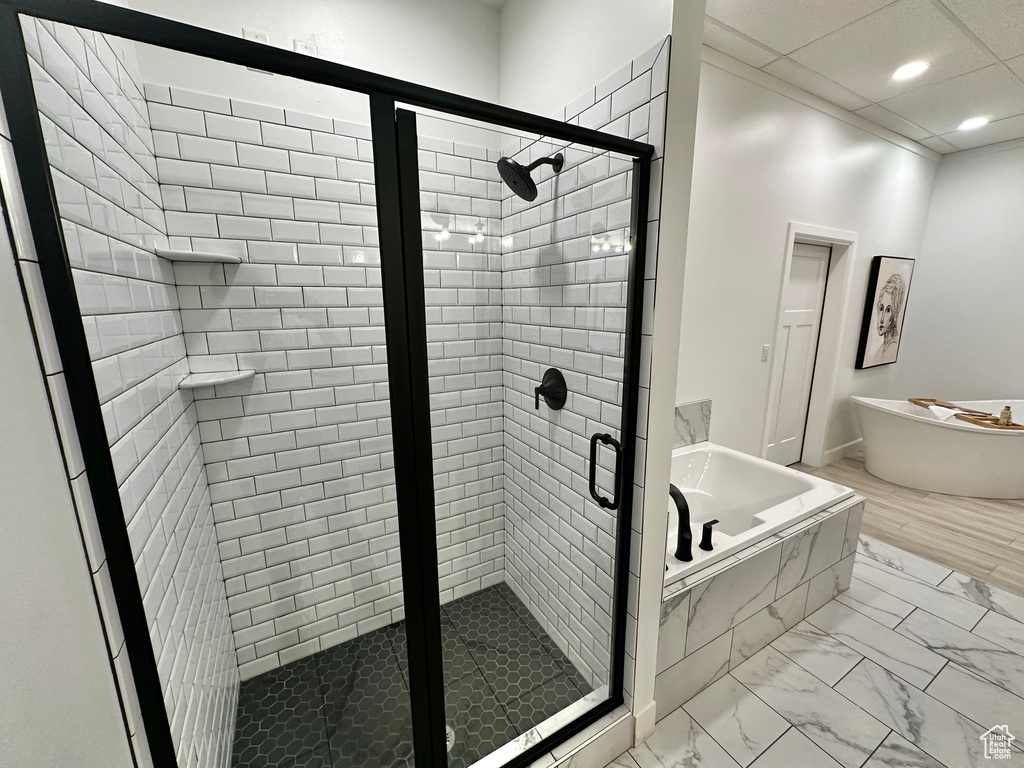 Bathroom with tile flooring, shower with separate bathtub, and a drop ceiling