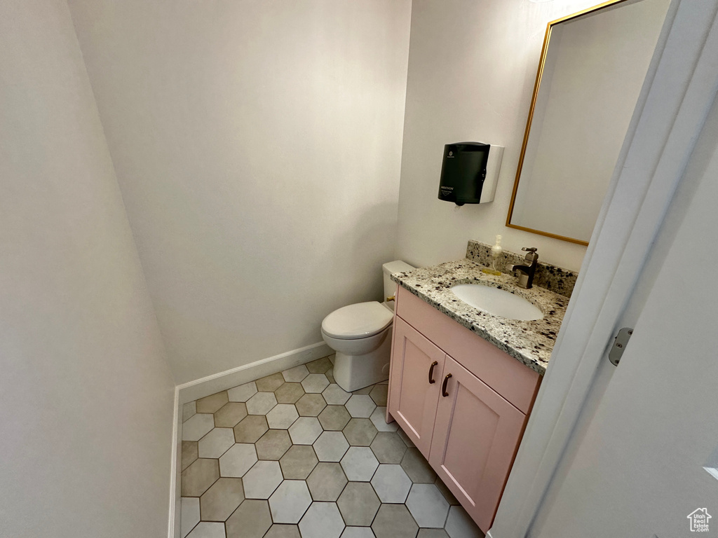 Bathroom with tile flooring, vanity, and toilet