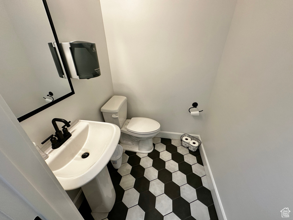 Bathroom featuring sink, tile flooring, and toilet