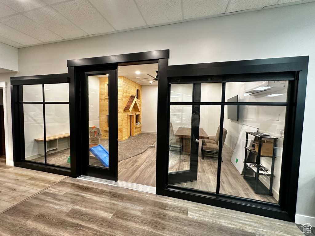 Interior space featuring hardwood / wood-style floors, ceiling fan, and a drop ceiling