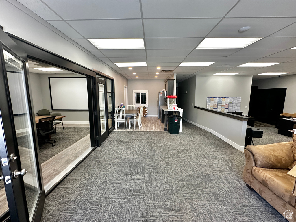 Interior space with a paneled ceiling and carpet