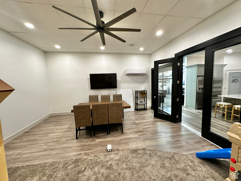 Living room with wood-type flooring, ceiling fan, french doors, and a drop ceiling