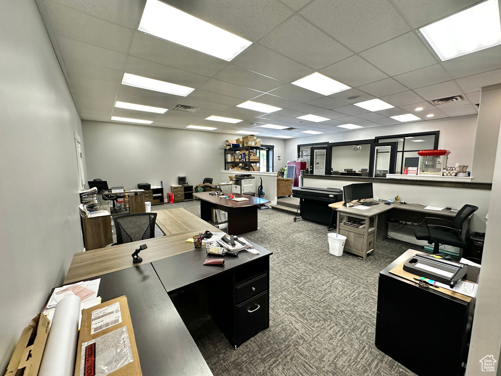 Home office with carpet floors and a drop ceiling