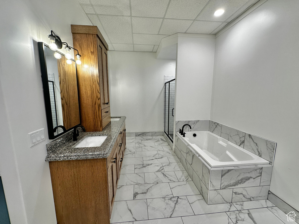 Bathroom with tile flooring, a drop ceiling, shower with separate bathtub, and vanity