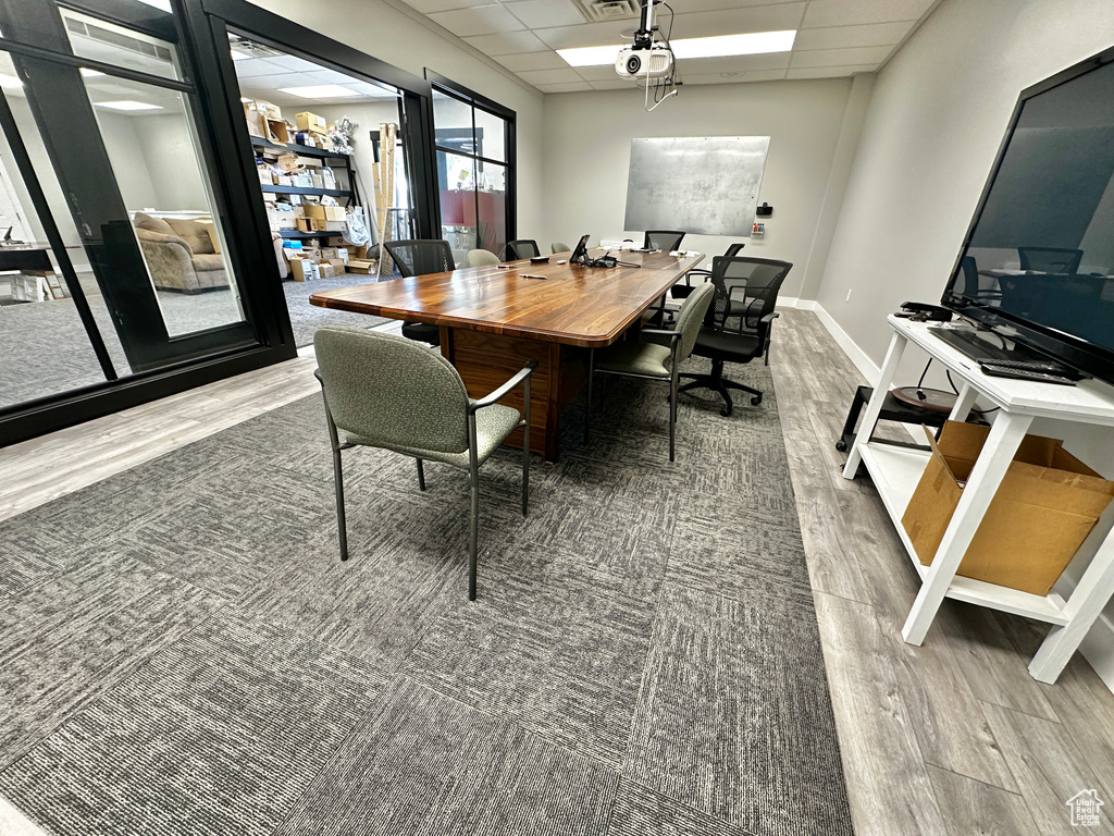 Dining area featuring hardwood / wood-style flooring and a drop ceiling