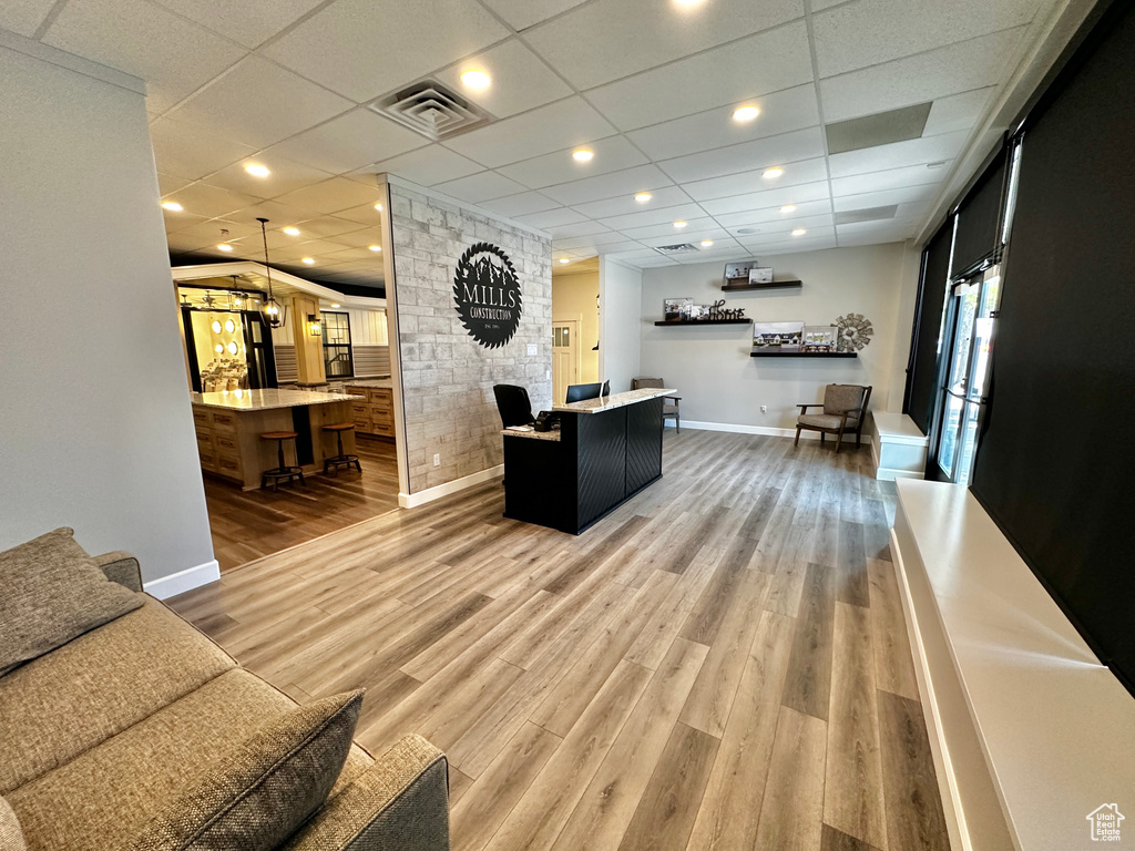 Living room featuring a drop ceiling and wood-type flooring