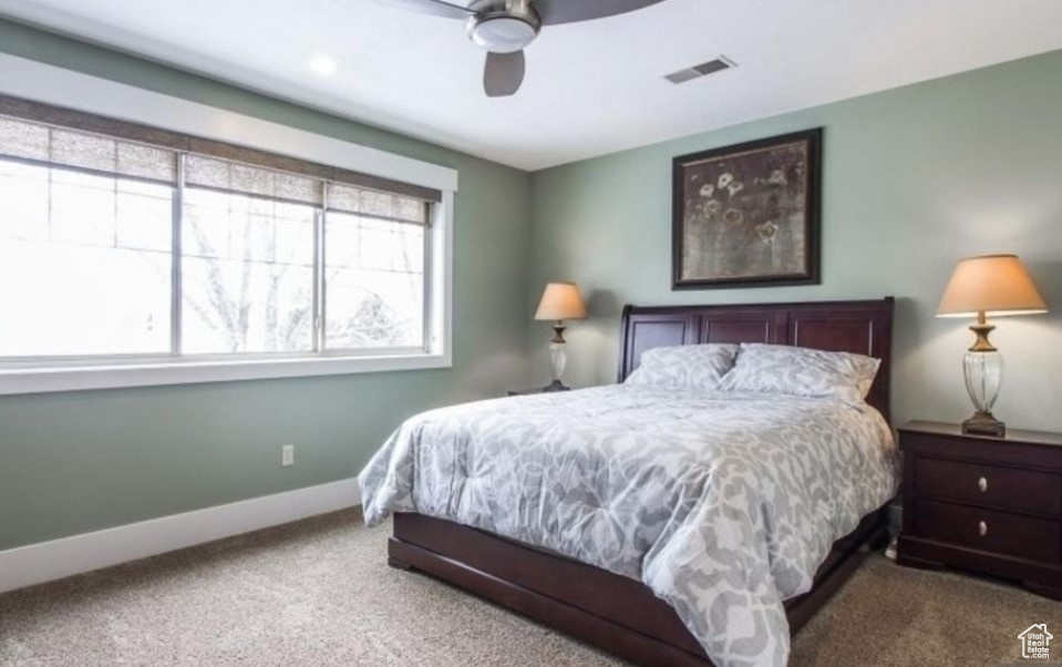 Carpeted bedroom with ceiling fan