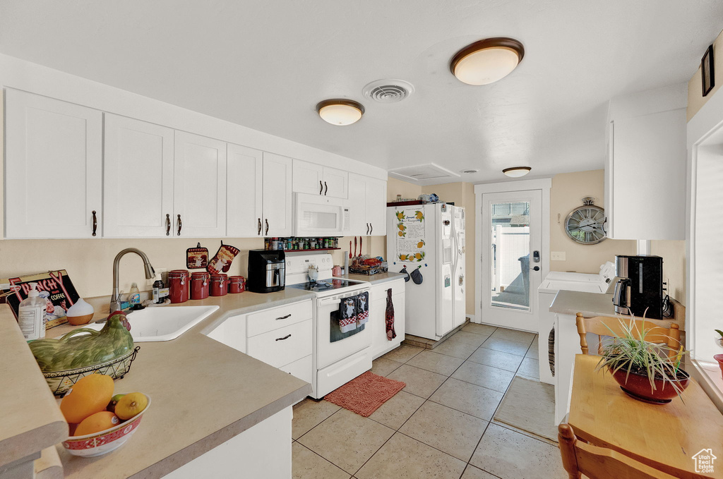 Kitchen with sink, white cabinetry, white appliances, and light tile floors