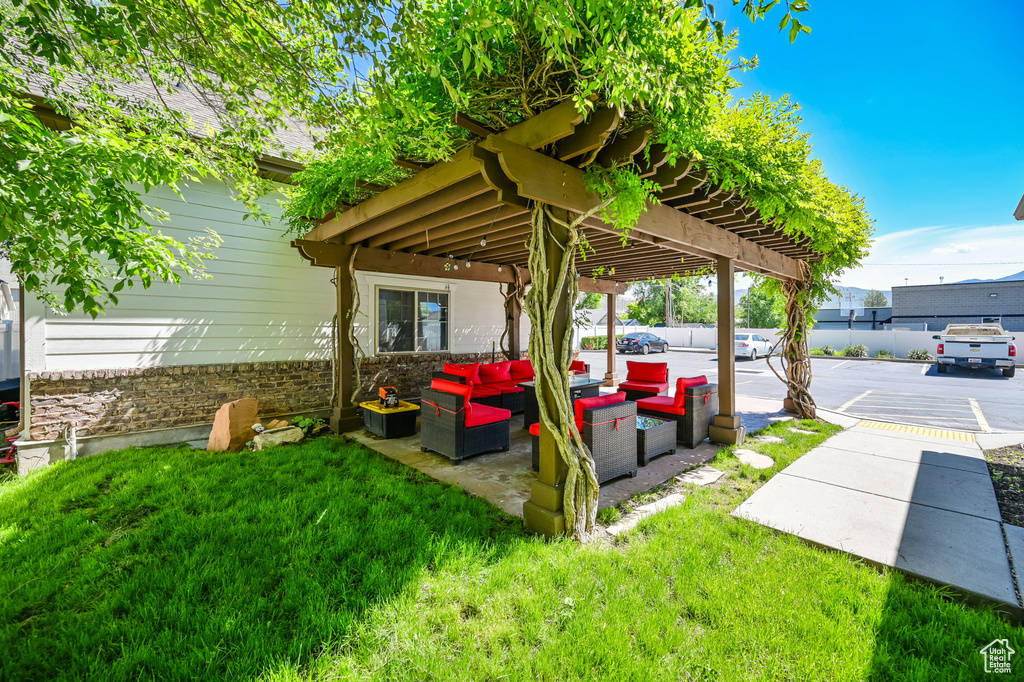 Exterior space featuring a pergola and a lawn