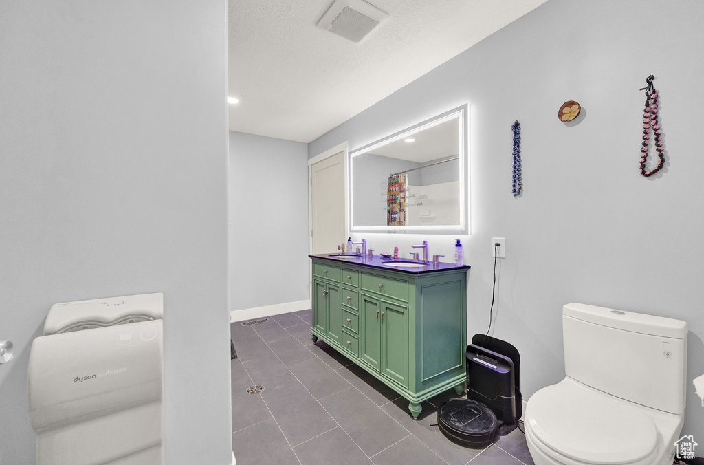 Bathroom with tile flooring, vanity, and toilet