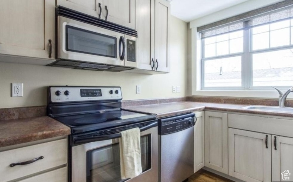 Kitchen featuring wood-type flooring, appliances with stainless steel finishes, and sink