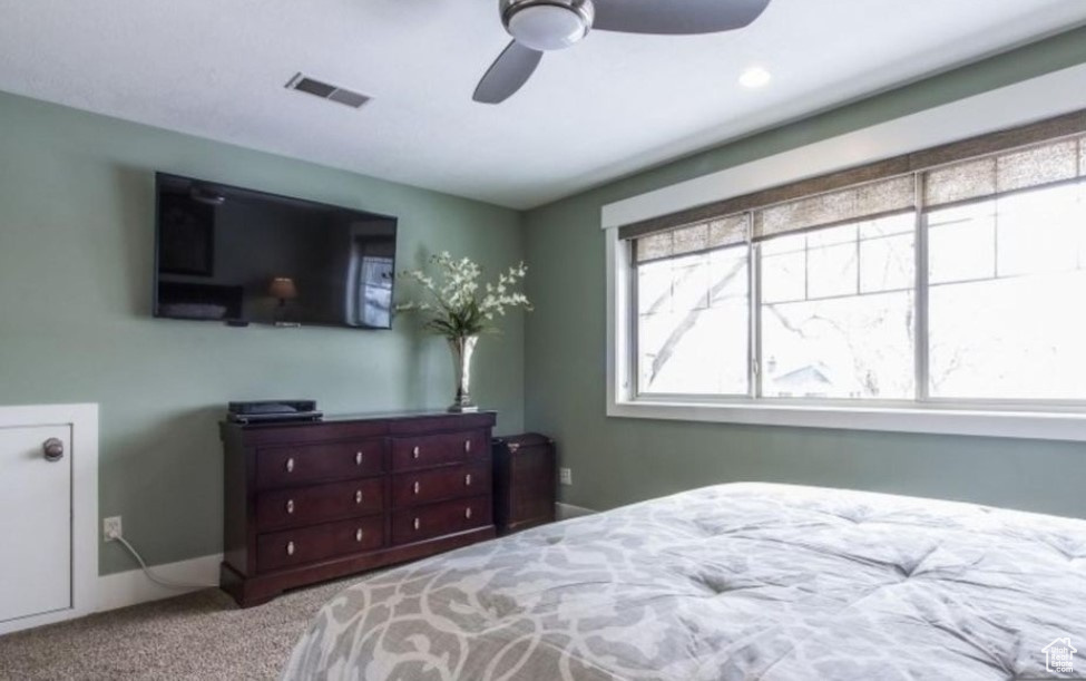 Carpeted bedroom featuring ceiling fan