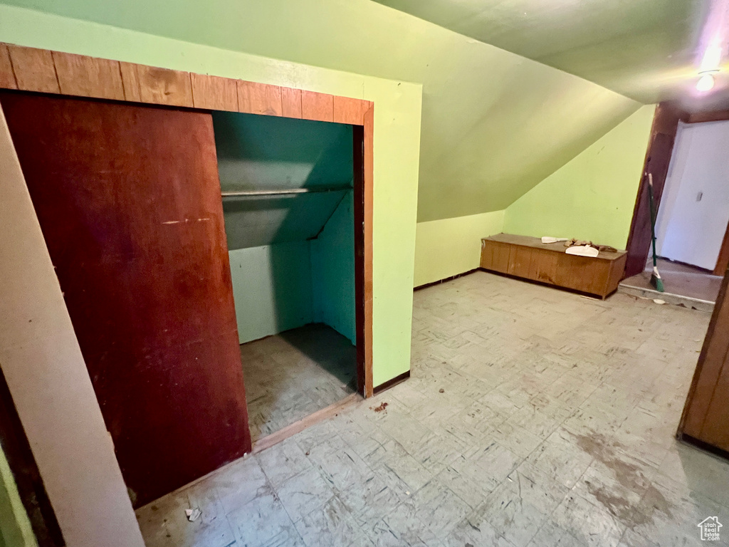 Unfurnished bedroom with lofted ceiling and a closet