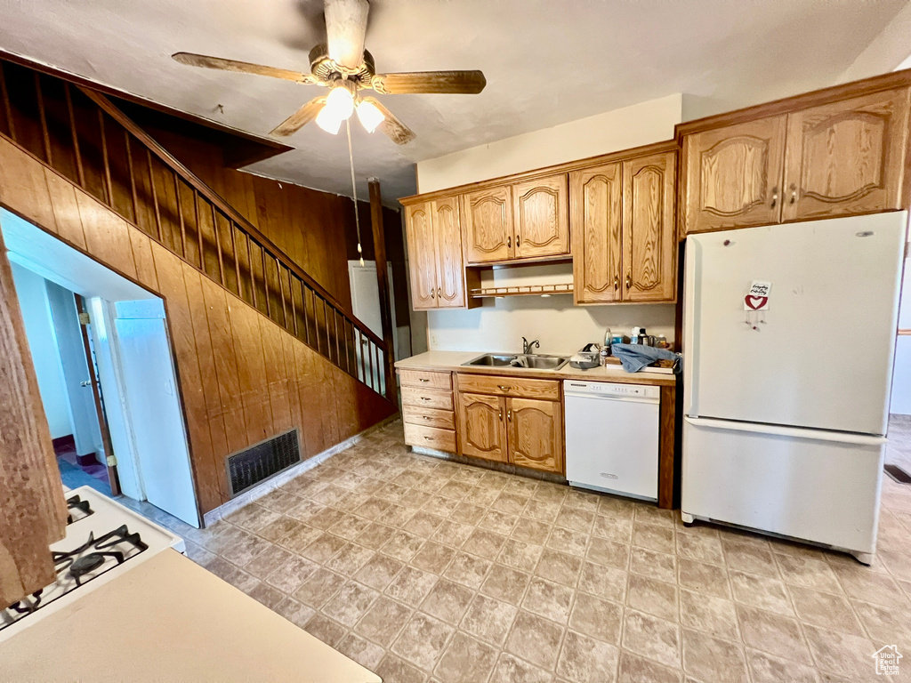 Kitchen with white appliances, sink, ceiling fan, and light tile floors