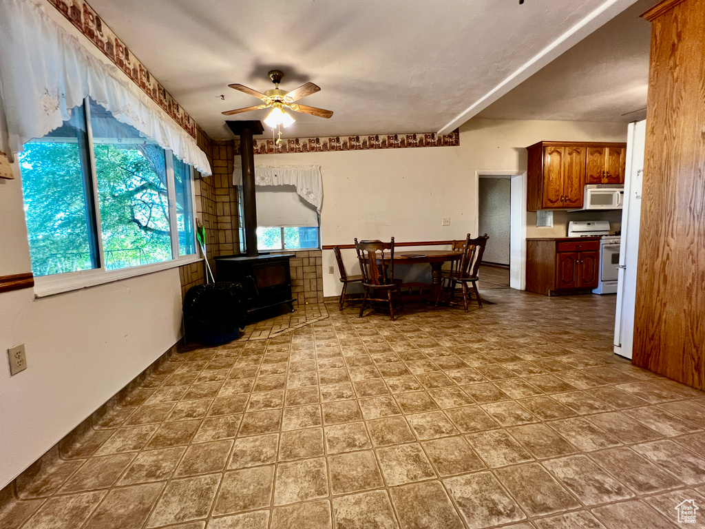 Interior space featuring ceiling fan, a wood stove, and tile floors