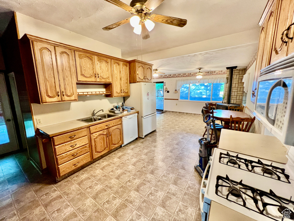 Kitchen with ceiling fan, sink, white appliances, and light tile floors