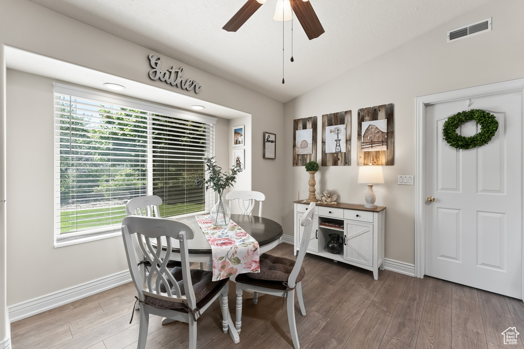 Dining area featuring wood-type flooring, ceiling fan, and lofted ceiling