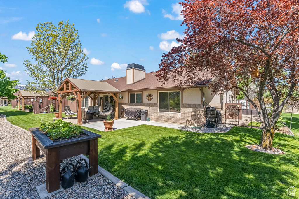 Back of property featuring a yard and a patio area