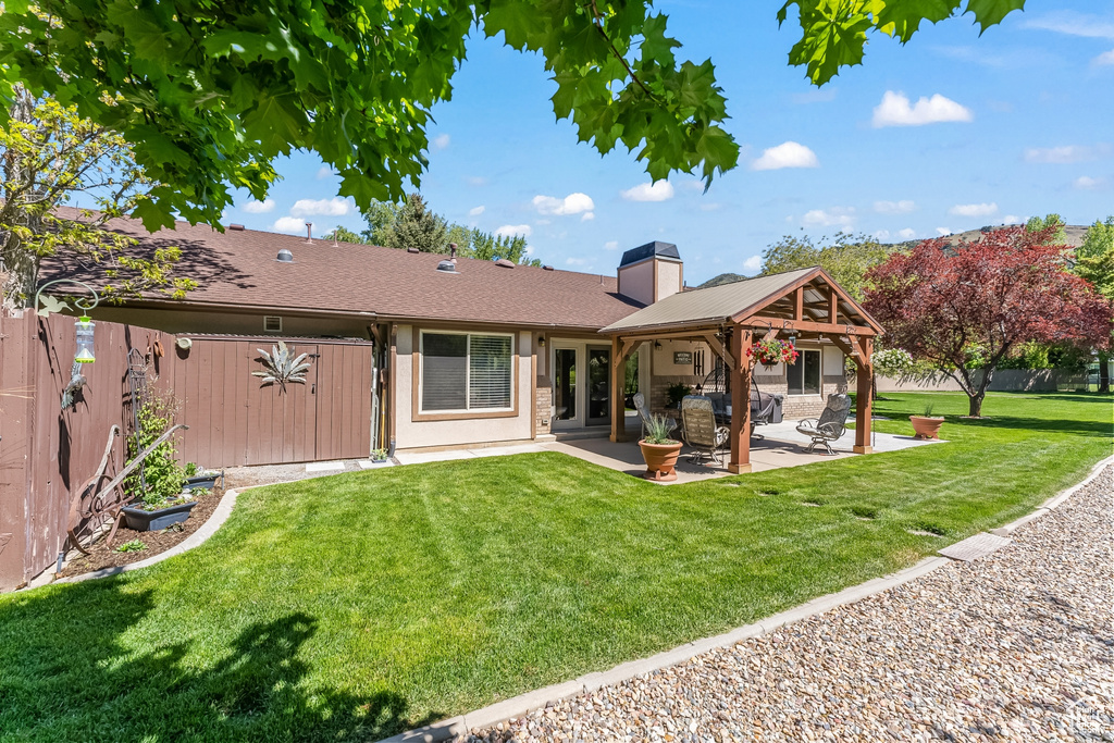 Rear view of property featuring a patio and a yard