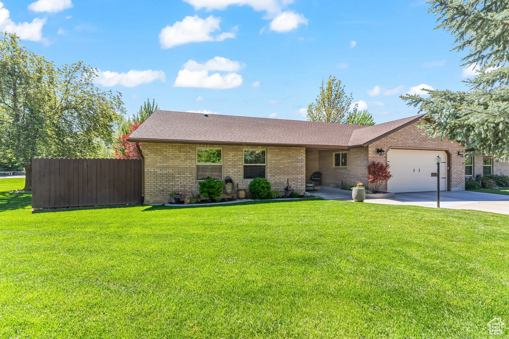 Ranch-style home with a garage and a front yard