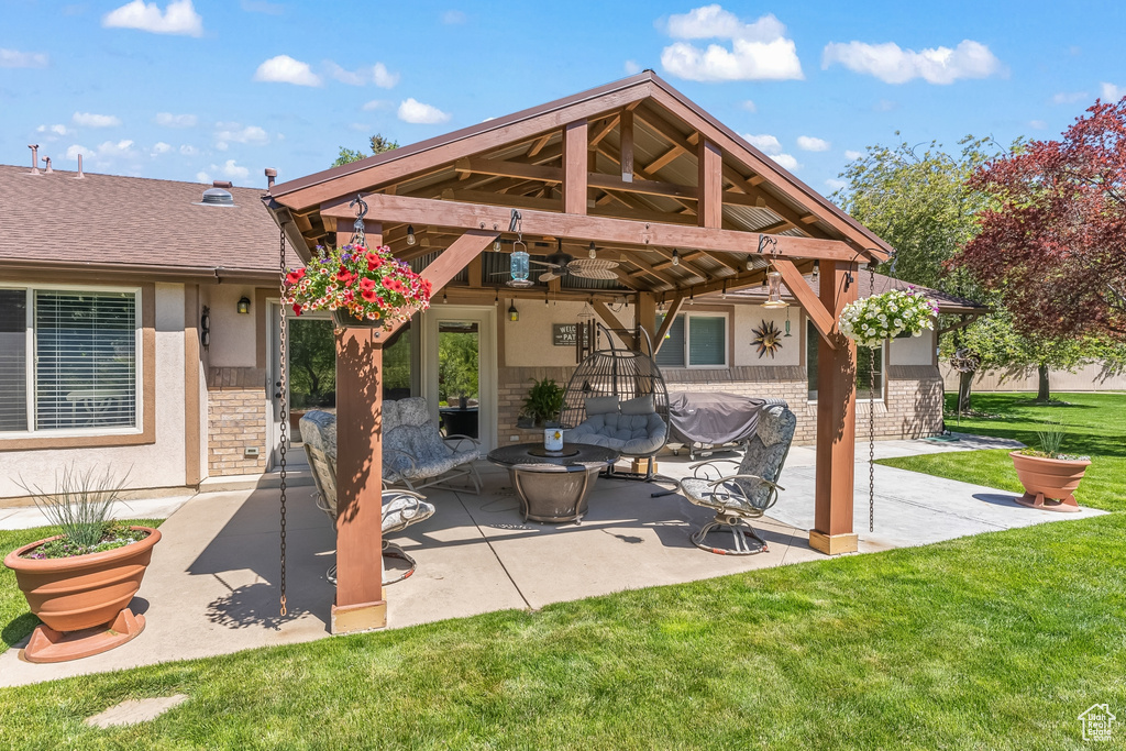 Back of property featuring a patio, a yard, and ceiling fan