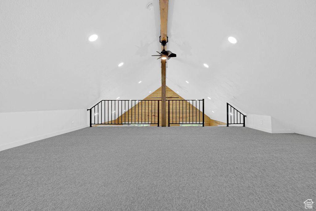 Interior space featuring carpet flooring, beamed ceiling, and ceiling fan