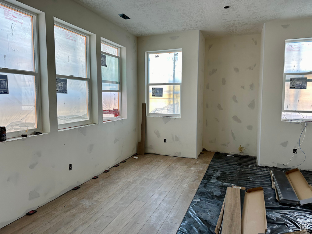 Spare room featuring a textured ceiling and light hardwood / wood-style floors