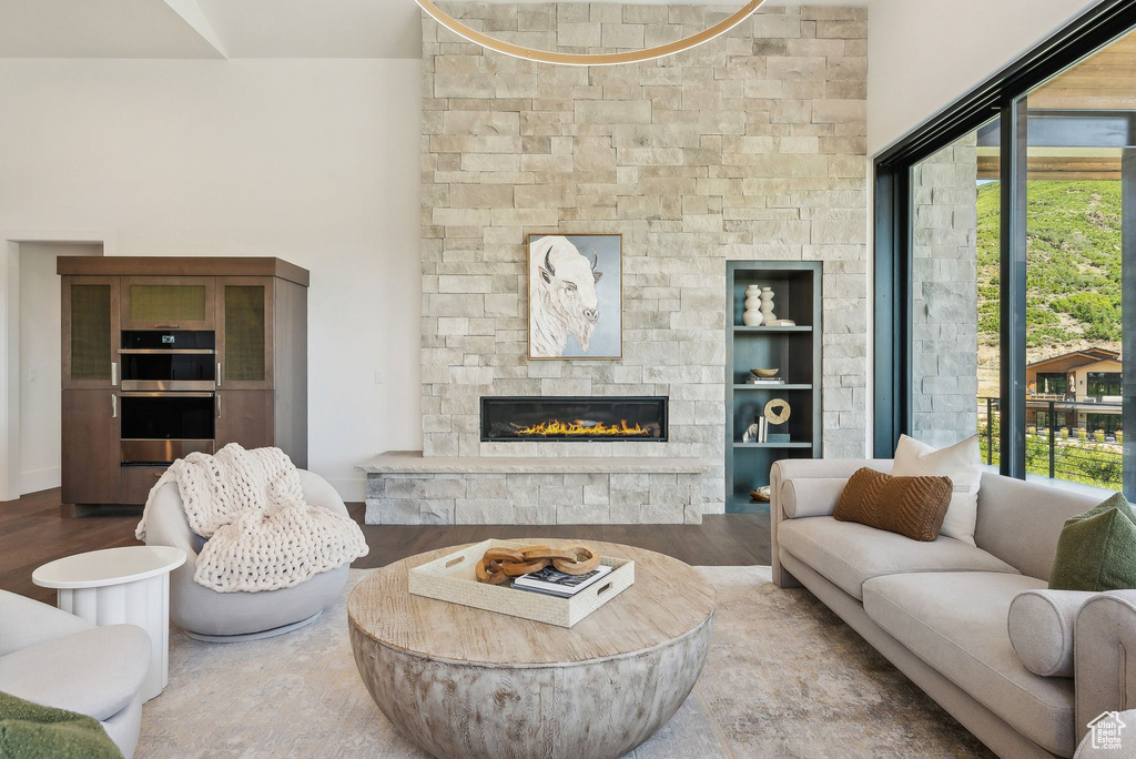 Living room with hardwood / wood-style floors and a stone fireplace