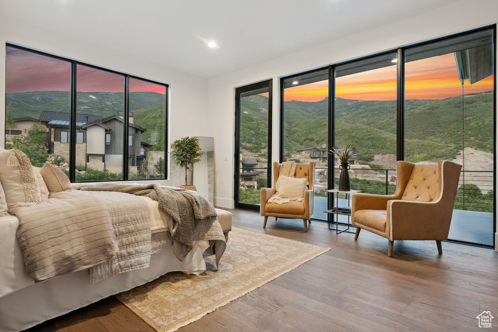 Bedroom featuring hardwood / wood-style flooring, a mountain view, and access to outside