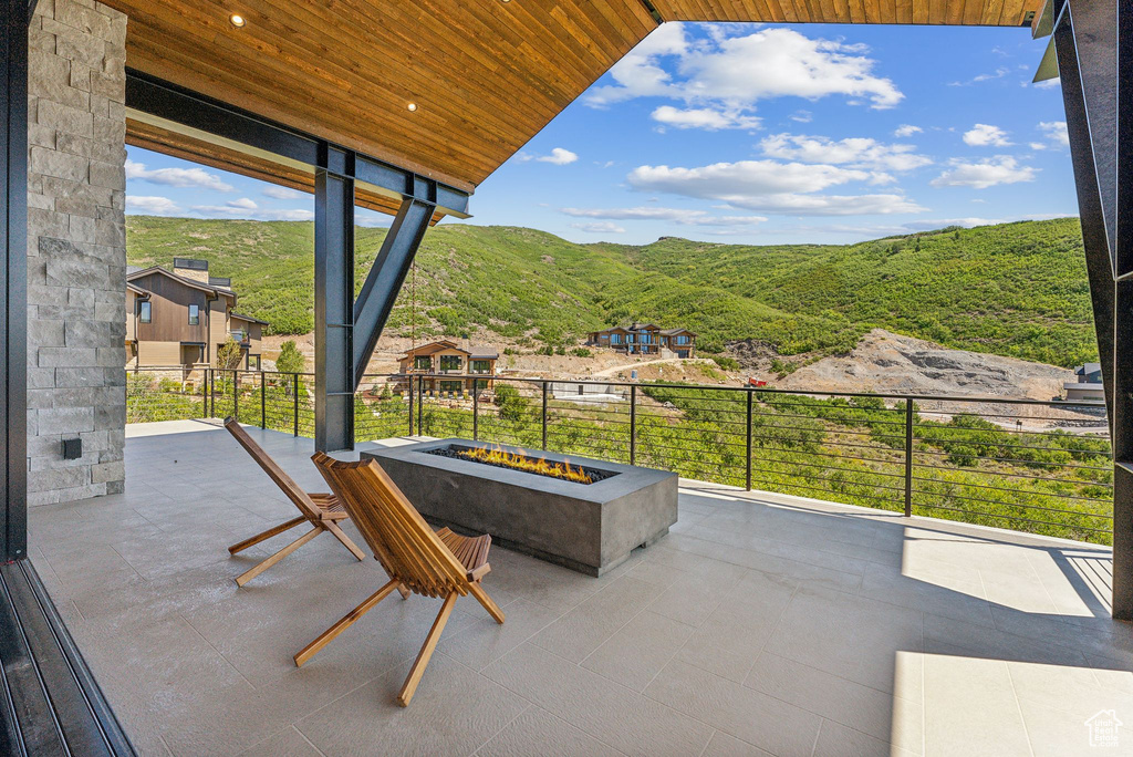 View of patio with a mountain view and an outdoor fire pit