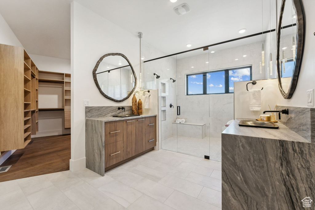 Bathroom featuring a shower with shower door, vanity, and wood-type flooring