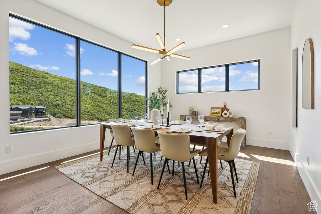 Dining space featuring a mountain view, an inviting chandelier, and hardwood / wood-style flooring